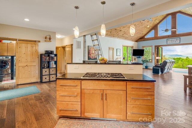 kitchen with stainless steel gas stovetop, light wood finished floors, visible vents, open floor plan, and washer / clothes dryer