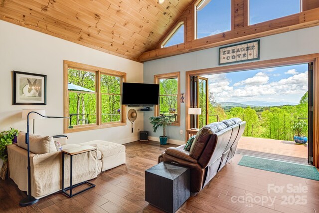 living room with wood finished floors, baseboards, high vaulted ceiling, and wooden ceiling