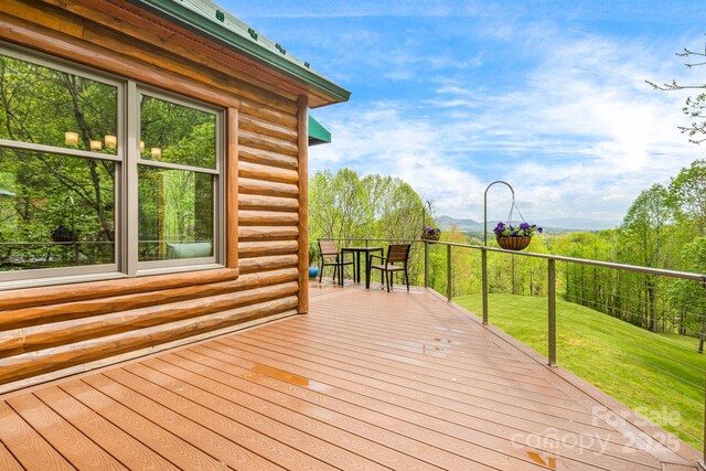 wooden terrace featuring a lawn