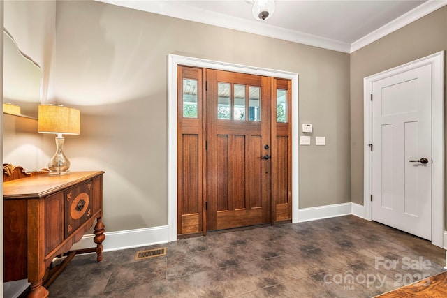 entryway with baseboards, ornamental molding, and visible vents