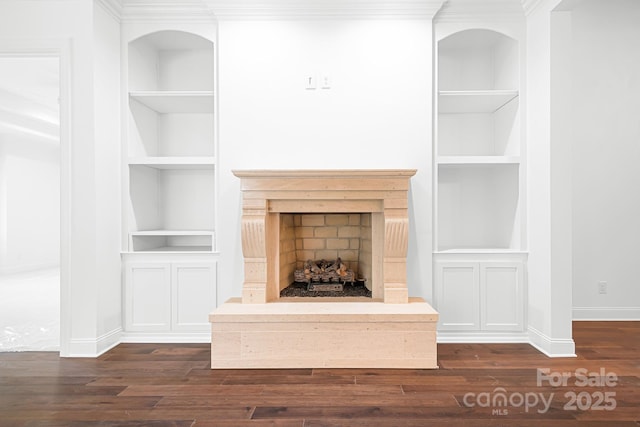 17408 Summer Place Dr, Cornelius, NC 28031 - unfurnished living room with built in shelves, dark wood-style floors, baseboards, ornamental molding, and a fireplace with raised hearth