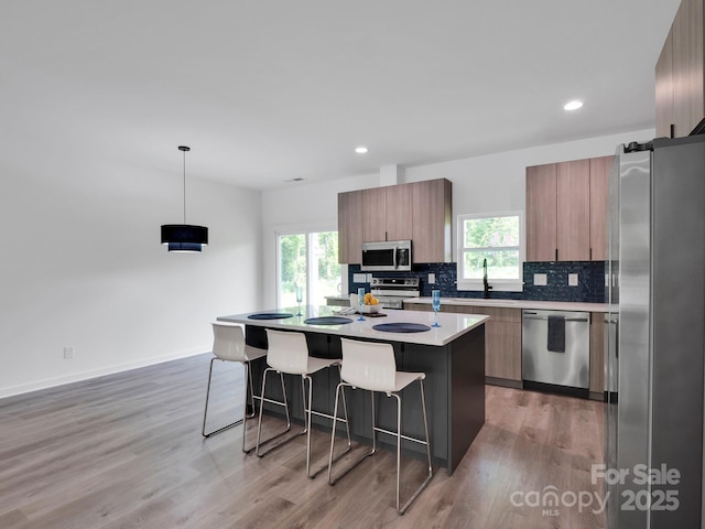 kitchen featuring appliances with stainless steel finishes, modern cabinets, and a kitchen bar