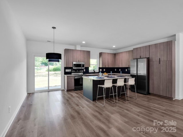 kitchen featuring a sink, appliances with stainless steel finishes, a healthy amount of sunlight, and tasteful backsplash