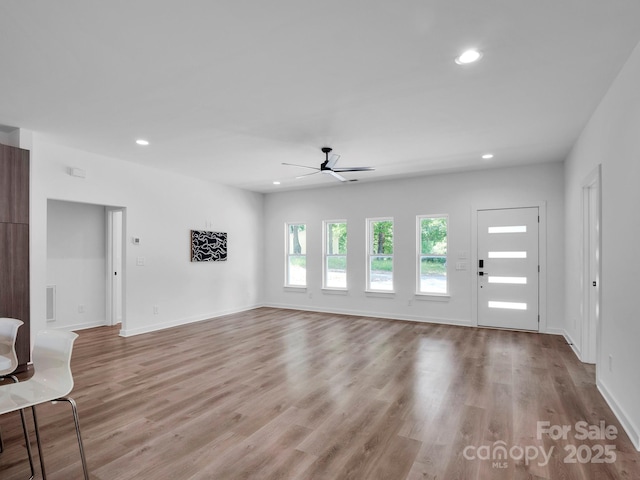 unfurnished living room featuring baseboards, ceiling fan, light wood-type flooring, and recessed lighting