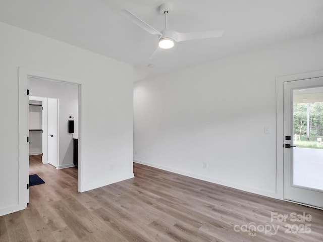 spare room featuring baseboards, ceiling fan, and wood finished floors