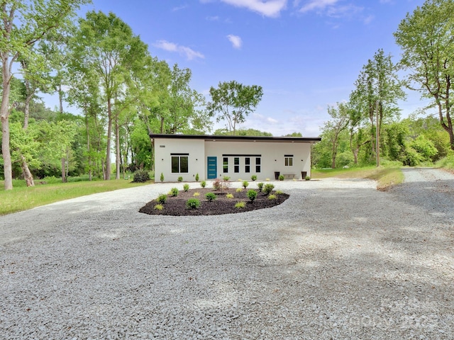 view of front of property with curved driveway and stucco siding