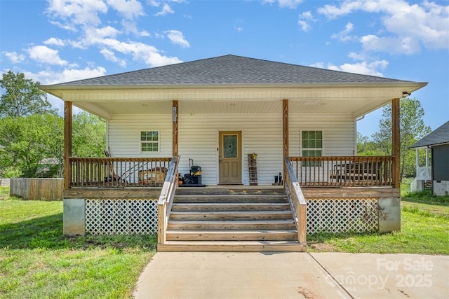 view of front of home with roof with shingles, a front lawn, and covered porch