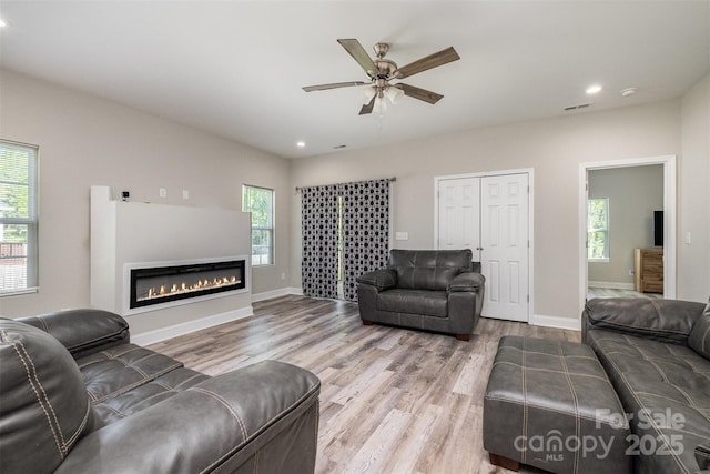 living area with a wealth of natural light, recessed lighting, and wood finished floors
