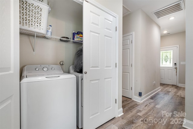 laundry room with separate washer and dryer, baseboards, visible vents, laundry area, and wood finished floors