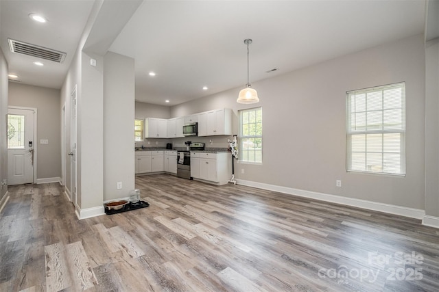 kitchen with baseboards, white cabinetry, light wood-style floors, visible vents, and appliances with stainless steel finishes