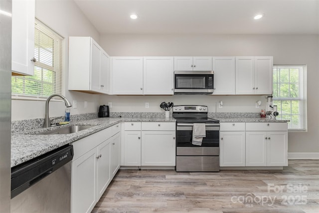kitchen with recessed lighting, white cabinetry, a sink, and appliances with stainless steel finishes