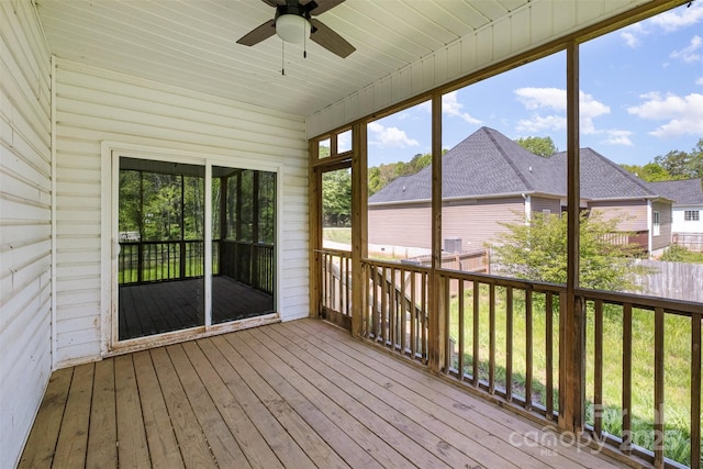 unfurnished sunroom featuring a ceiling fan and plenty of natural light