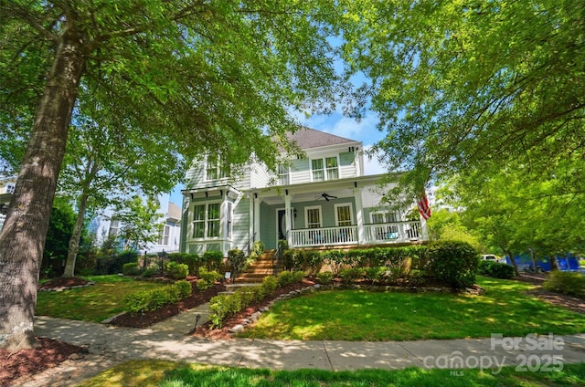 view of front of property featuring a ceiling fan, covered porch, and a front yard