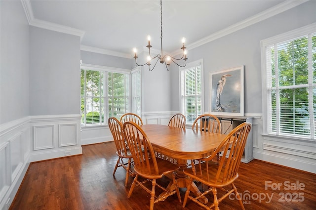 dining room featuring dark wood-style flooring, wainscoting, an inviting chandelier, ornamental molding, and a decorative wall