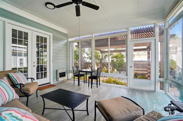 sunroom featuring heating unit, ceiling fan, and french doors