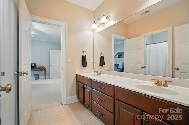 bathroom with a sink, tile patterned floors, double vanity, and visible vents