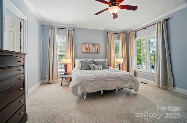 carpeted bedroom featuring baseboards, ornamental molding, a ceiling fan, and visible vents
