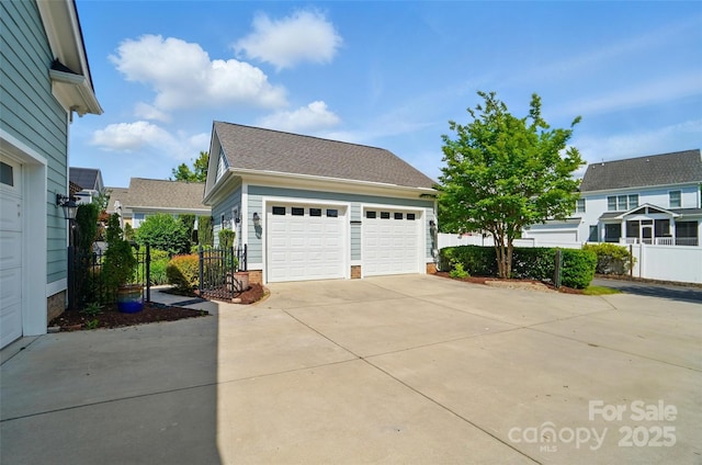 view of home's exterior with fence, a shingled roof, and a garage