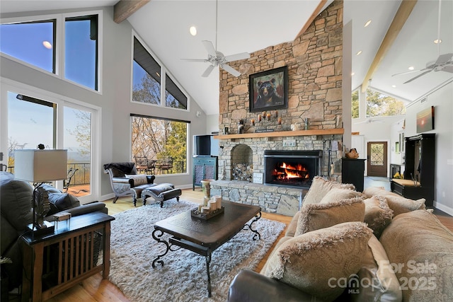 living area featuring high vaulted ceiling, beamed ceiling, and a ceiling fan