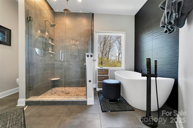bathroom with tile patterned flooring, recessed lighting, baseboards, a freestanding tub, and a stall shower