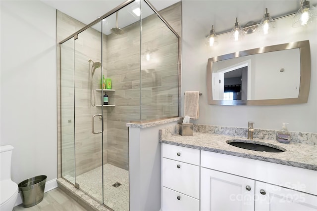full bath featuring vanity, a stall shower, and toilet