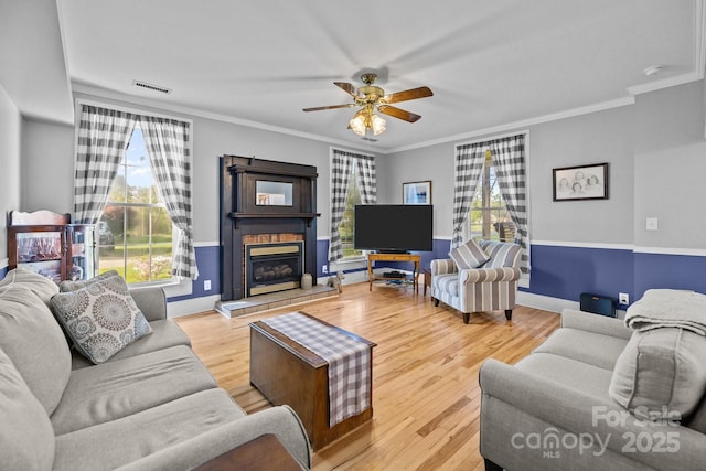 living room featuring ornamental molding, a ceiling fan, and wood finished floors