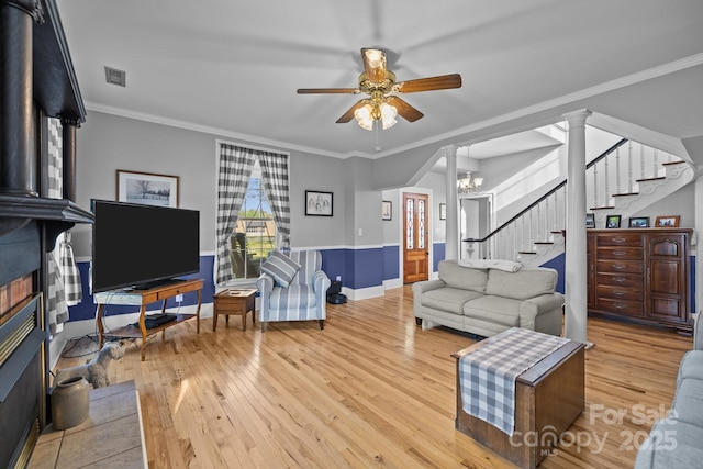 living area with visible vents, baseboards, a ceiling fan, hardwood / wood-style flooring, and stairs