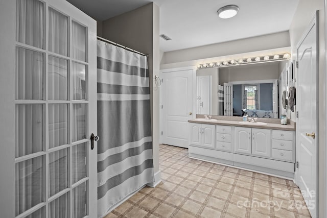 full bathroom with a sink, visible vents, tile patterned floors, and double vanity