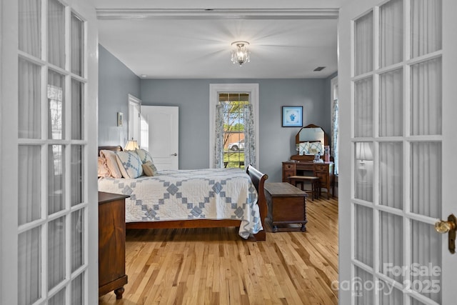 bedroom with french doors, wood finished floors, and visible vents