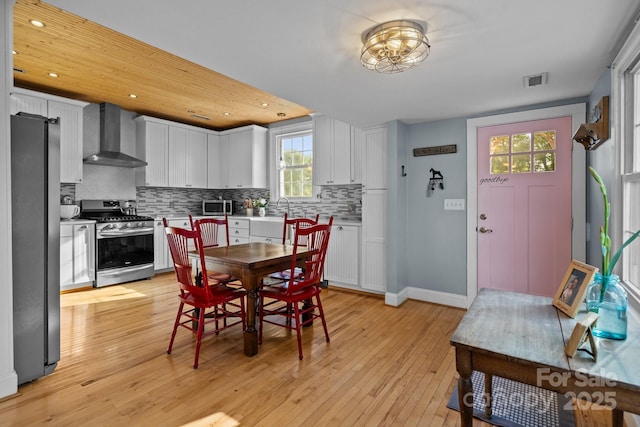 dining room featuring visible vents, baseboards, recessed lighting, and light wood-style floors
