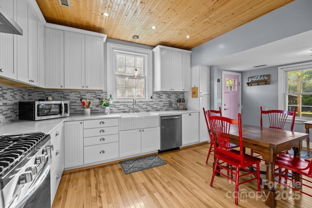 kitchen with tasteful backsplash, light countertops, wooden ceiling, and appliances with stainless steel finishes