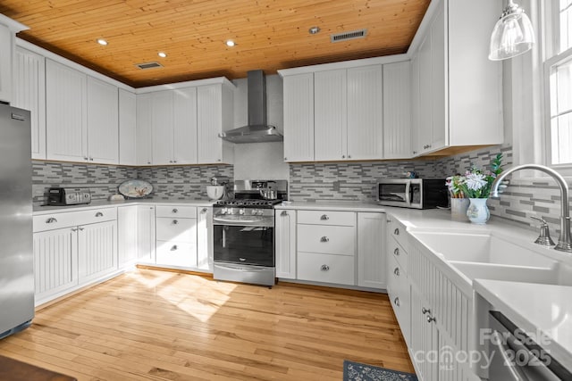 kitchen with light countertops, wall chimney exhaust hood, and stainless steel appliances