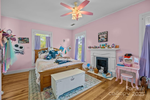 bedroom with light wood-style floors, multiple windows, and visible vents
