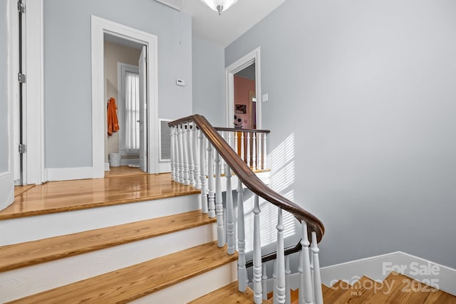 staircase with wood finished floors and baseboards