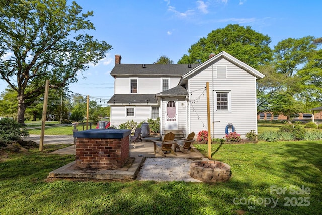 rear view of house featuring a yard, an outdoor fire pit, a patio, fence, and a chimney