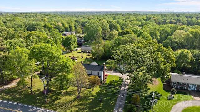 drone / aerial view featuring a wooded view