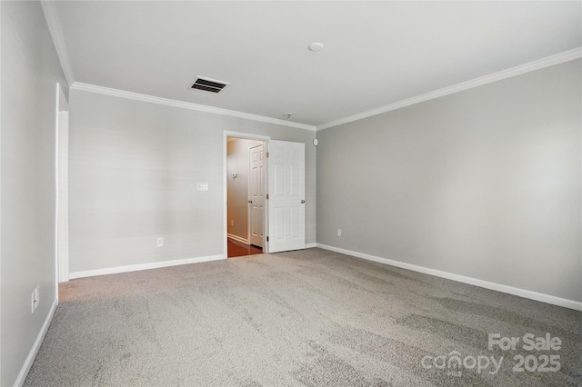 empty room featuring carpet floors, visible vents, baseboards, and ornamental molding