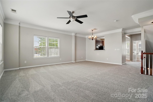 empty room with carpet floors, ornamental molding, and ceiling fan with notable chandelier