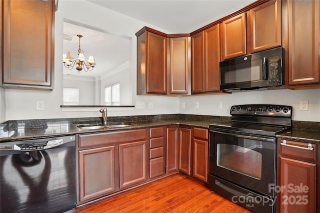 kitchen featuring crown molding, a sink, black appliances, a chandelier, and light wood-style flooring