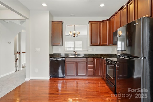 kitchen featuring recessed lighting, a sink, baseboards, black appliances, and a chandelier