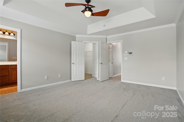 unfurnished bedroom featuring light carpet, a raised ceiling, and ornamental molding