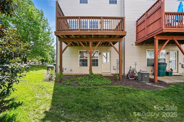 rear view of house featuring central AC, a wooden deck, and a lawn