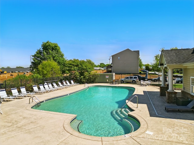 pool featuring fence and a patio