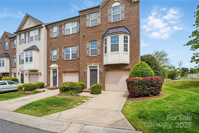7753 Jackson Pond Dr, Charlotte, NC 28273 - view of front of house with concrete driveway, brick siding, an attached garage, and a front lawn