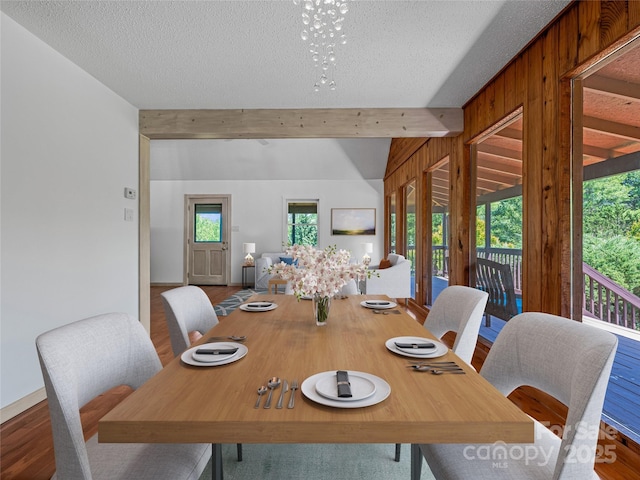 dining space with a textured ceiling, plenty of natural light, and wood finished floors