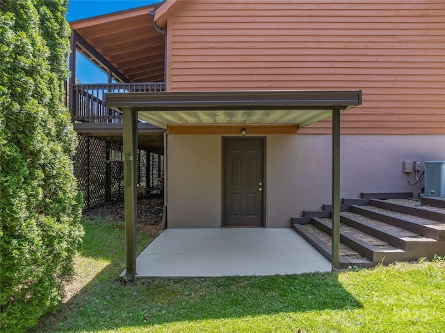 doorway to property featuring a lawn, a deck, and stucco siding