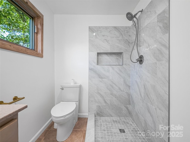 full bath featuring vanity, toilet, baseboards, tile patterned floors, and a tile shower