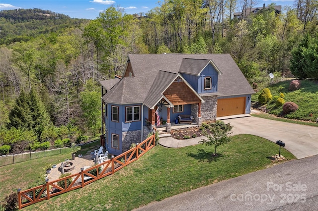 334 Willow Top Ln, Lake Lure, NC 28746 - view of front of home featuring stone siding, covered porch, a forest view, an outdoor fire pit, and concrete driveway