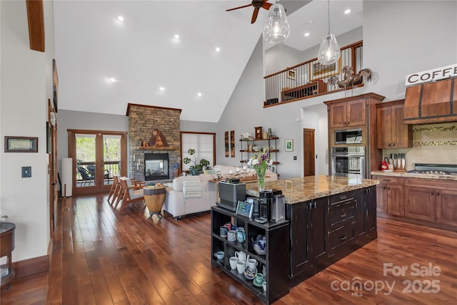 334 Willow Top Ln, Lake Lure, NC 28746 - kitchen with stainless steel appliances, high vaulted ceiling, ceiling fan, dark wood-type flooring, and light stone countertops