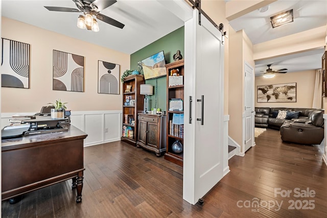 2262 Galloway Ln SW, Concord, NC 28025 - home office featuring wainscoting, dark wood finished floors, ceiling fan, and a barn door